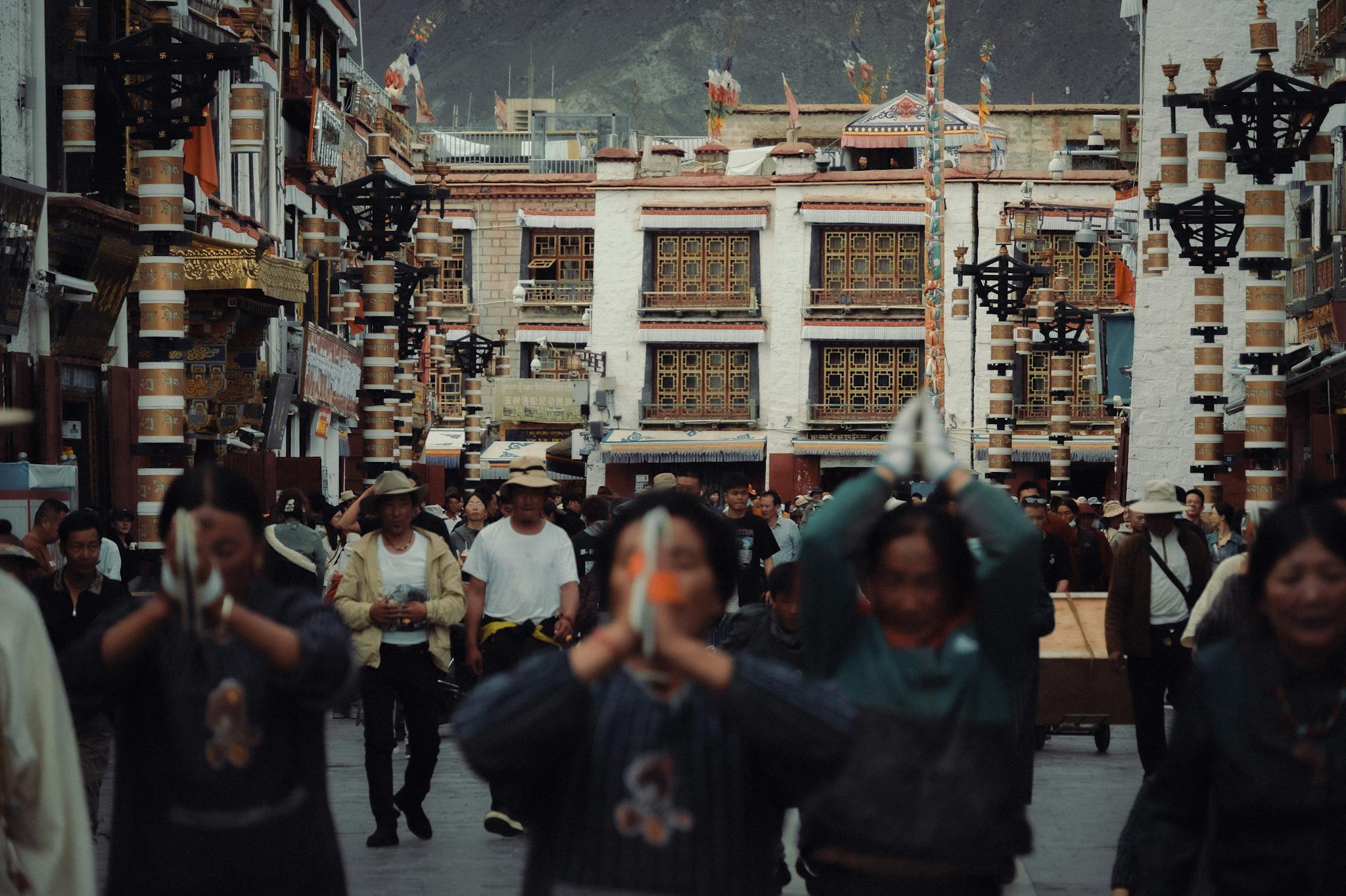 A busy street in Tibet filled with pilgrims and traditional architecture, capturing cultural essence.