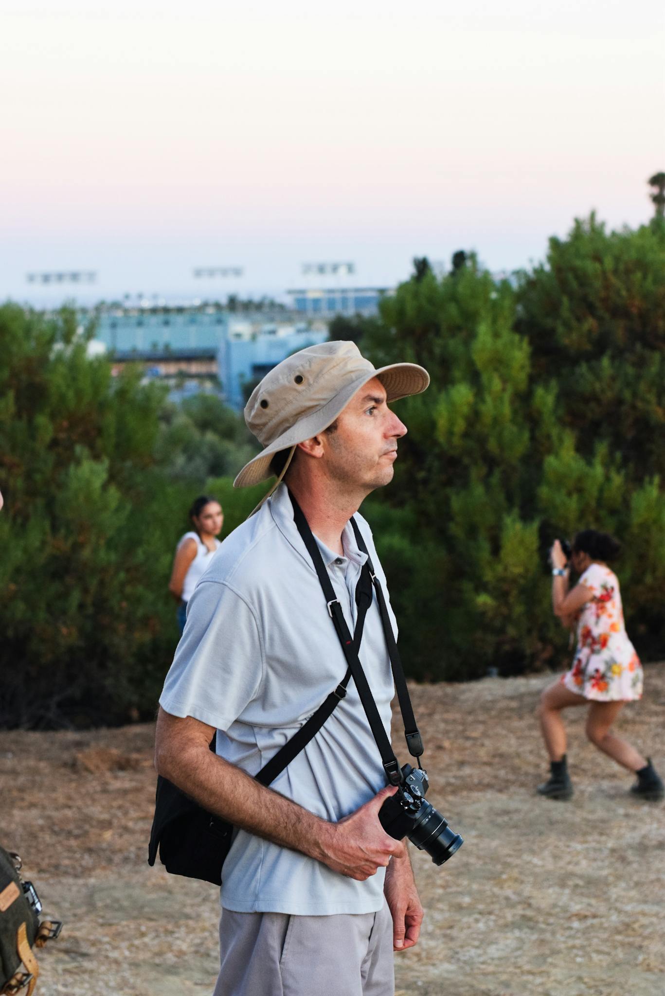 People enjoy photography in a Los Angeles park at dusk, with scenic background.